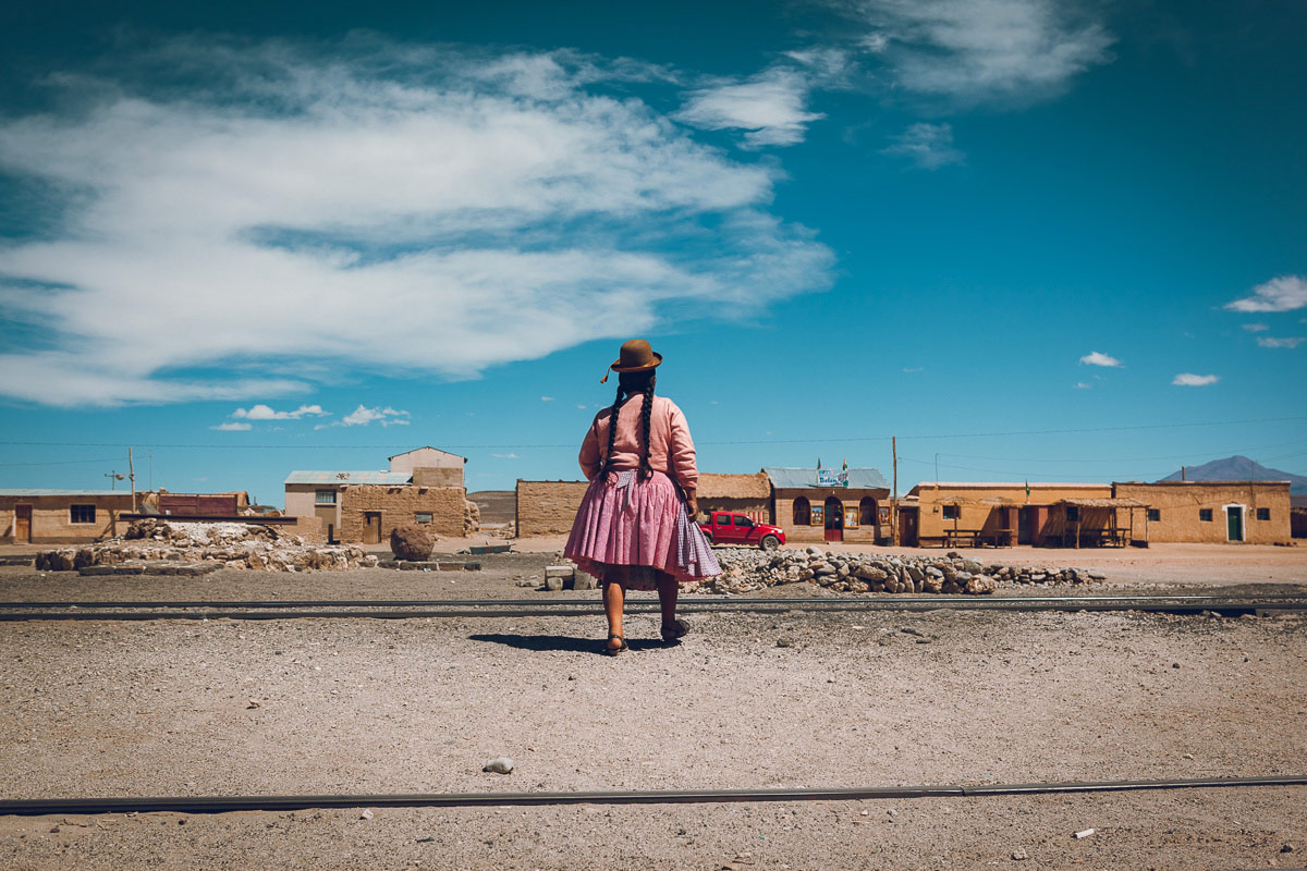 A cholita walks through the sleepers in Julaca, Bolivia