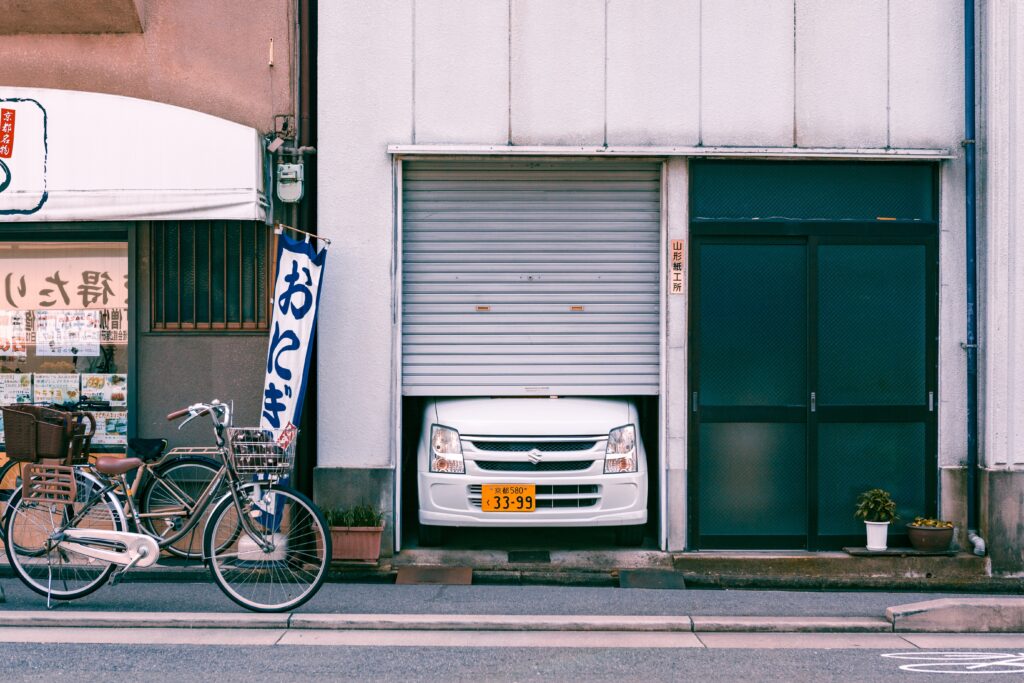 Vista de una calle de Kyoto, con uno de sus característicos coches asomando por el garaje de una vivienda